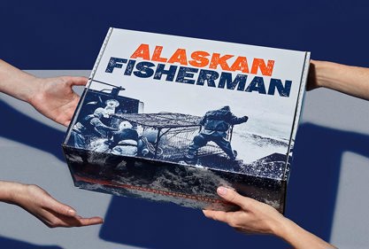 Kurýr předává zákazníkovi box divokých ryb od Alaskan Fisherman